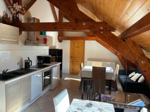 a kitchen and dining room with wooden ceilings and a table at Le Rocher des Ducs, Chambres d'hôtes, parking privé, abris motos in Le Glaizil +24 photos