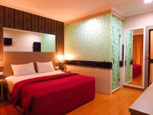 una camera da letto con un letto grande con una coperta rossa di Hotel Menara Lexus a Polonia Airport