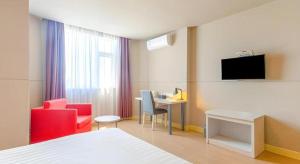a hotel room with a bed and a table and chairs at Jinjiang Inn Zhuhai Xiangzhou Qinglv Middle Road Theater in Zhuhai