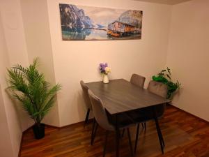 ein Esstisch mit Stühlen und ein Gemälde an der Wand in der Unterkunft Gemütliches Apartment in Giengen an der Brenz