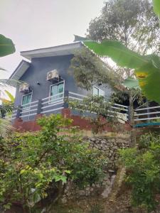 a blue house with a stone wall at Teratak Desa Cemerlang 2 in Kuala Kangsar +3 photos