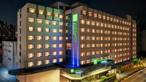 a hotel building with a blue light on it at Holiday Inn Express Shanghai Changyang Road by IHG in Shanghai