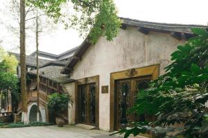 a house with a gate and a building at Eden Club House in Tongxiang