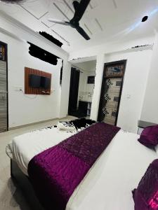 Un dormitorio con una cama grande con una manta morada. en Staylo master Inn, en Lucknow