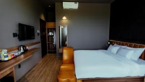 una camera d'albergo con un letto e una televisione di One and Only Hotel - Đức Trọng a Lien Khuong Airport Altre 40 foto