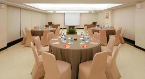a conference room with tables and chairs and a whiteboard at Grage Hotel Cirebon in Cirebon +160 photos