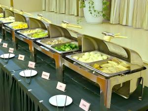 un buffet avec plusieurs plateaux de nourriture sur une table dans l'établissement GreenTree Eastern Zigong Huashang International City Huichuan Road Hotel, à Shuping