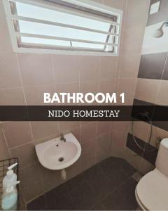 a bathroom with a toilet and a sink and a window at Home at Port Dickson in Port Dickson +12 photos