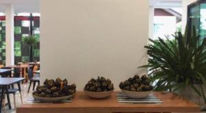 three bowls of fruit sitting on a wooden table at PIMDARA HOTEL in Ban Kaeo