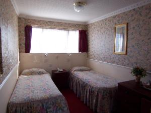 Cette chambre comprend 2 lits et une fenêtre. dans l'établissement Old Lamb Hotel, à Reading