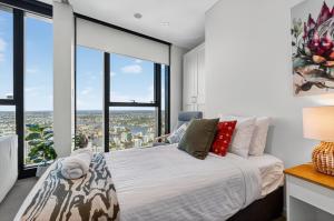 Un dormitorio con una cama y grandes ventanales. en Oasis Retreat on Level 71 in Skytower, en Brisbane 16 fotos más
