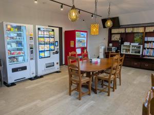 a dining room with a table and two refrigerators at くにまるイン in Kyotango