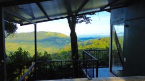 a room with a balcony with a view of the mountains at Monteverde Beaumont in La Cruz