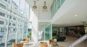 a lobby of a building with chairs and windows at B2 Nakhonsawan Premier Hotel in Nakhon Sawan