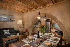 a dining room with a table and chairs and an archway at Neoria Houses in Chania