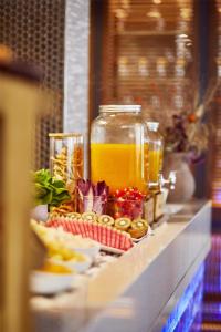 a buffet with a jar of orange juice and other food at Hyatt Centric Gran Via Madrid in Madrid
