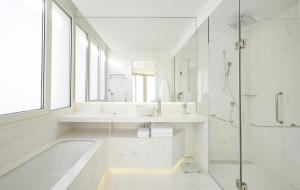 a white bathroom with a tub and a sink at Hyatt Centric Gran Via Madrid in Madrid +144 photos