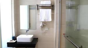 a bathroom with a sink and a mirror and a shower at Shell Ganzhou Central Theme Hotel in Ganzhou +167 photos