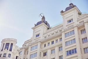 a building with a statue on the top at Hyatt Centric Gran Via Madrid in Madrid
