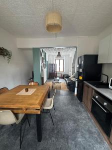 a kitchen and living room with a wooden table in a room at Le cocon aux portes des remparts in Boulogne-sur-Mer