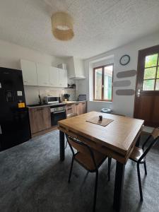 a kitchen with a wooden table and chairs in a room at Le cocon aux portes des remparts in Boulogne-sur-Mer