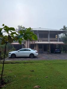 DharmastalaにあるFiner Things Retreat, Shivalli Homestay Dharmasthala -KSTDC Approvedの家の前に駐車した白車