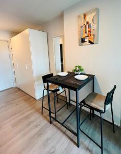 Un comedor con una mesa y sillas negras. en Life city 1, en Bang Chak