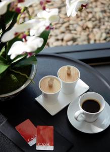 a table with two cups of coffee and a vase with flowers at Casa Residence Hotel in Bangkok