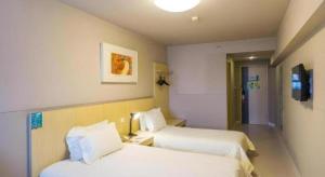 a hotel room with two beds and a tv at Magnotel Business Xuzhou Jinying Sudi Road Metro Station in Xuzhou +160 photos