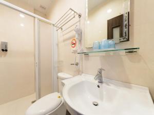 a white bathroom with a sink and a toilet at 花蓮市綠宿民宿 in Hualien City