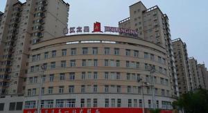 Un gran edificio con un cartel encima. en Jinjiang Inn Pingliang West Railway Station Xuanhe New City, en Pingliang