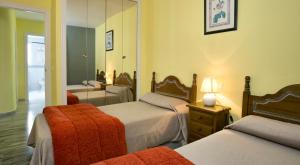 a bedroom with two beds and a mirror at Ona Campanario in La Cala de Mijas