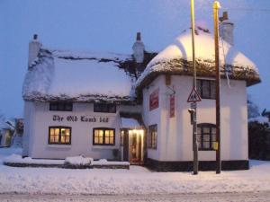 Un bâtiment blanc avec de la neige sur le toit dans l'établissement Old Lamb Hotel, à Reading