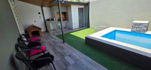 a living room with a swimming pool and chairs at Casa de Agus - Con pileta climatizada in Córdoba