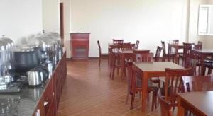 a restaurant with wooden tables and tables and chairs at GreenTree Inn Weihai Port in Weihai