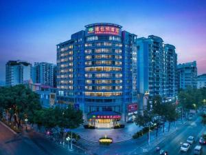 a tall blue building with a lit up building at Vienna Hotel Guangxi Guilin 7-Star Wanda Plaza in Guilin
