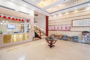 a lobby of a shopping mall with a table and chairs at GreenTree Inn Wuxi Guangrui Road Hotel in Wuxi