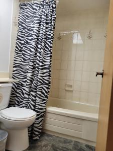a bathroom with a toilet and a bath tub at Singleton Room in a pet and smoke-free home in Winnipeg