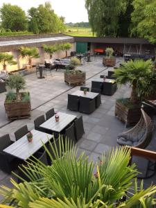 un patio al aire libre con mesas, sillas y plantas en Hotel Restaurant Cafe Houben, en Nunhem