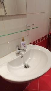 a white bathroom sink with a soap dispenser on it at апартамент Климент in Varna City