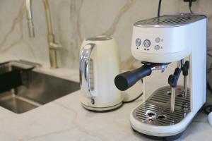 a white coffee maker sitting on a counter at Entire 2bed New Apartment in Waitara