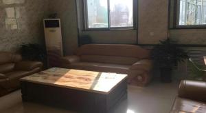 a living room with a couch and a table at Shell Hotel Taiyuan South Railway Station New Southeast Bus Station in Taiyuan +24 photos