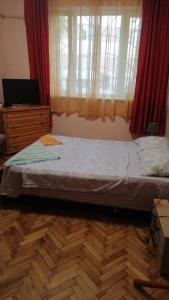 a bedroom with a bed and a dresser and a window at апартамент Климент in Varna City