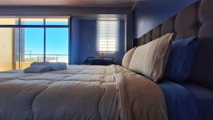a bedroom with a large bed with a view of the ocean at Céntrico apartamento con 2 baños, a pasos de restaurantes y agencias de turismo in Uyuni +18 photos