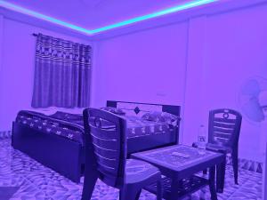 Risingresort في Jāmb: غرفة أرجوانية بها سرير وطاولة وكراسي