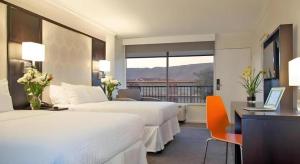 a hotel room with two beds and a desk with a laptop at Park Pointe Hotel in South San Francisco +13 photos