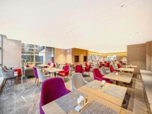 a restaurant with wooden tables and red chairs at City Comfort Inn Wuhan High Speed Railway Station in Wuhan