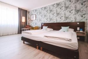 Best Western Hotel Ambassador في باوناتال: غرفة نوم بها سرير كبير في الغرفة