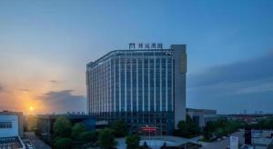 a tall building with a sign on top of it at Maison New Century Hotel Cixi in Hejiao