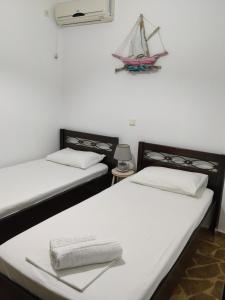 two beds in a room with a toy boat on the wall at Efi in Káto Alepokhórion +12 photos